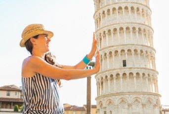 Immagine di una persona che sembra reggere la torre di Pisa grazie al principio di costanza